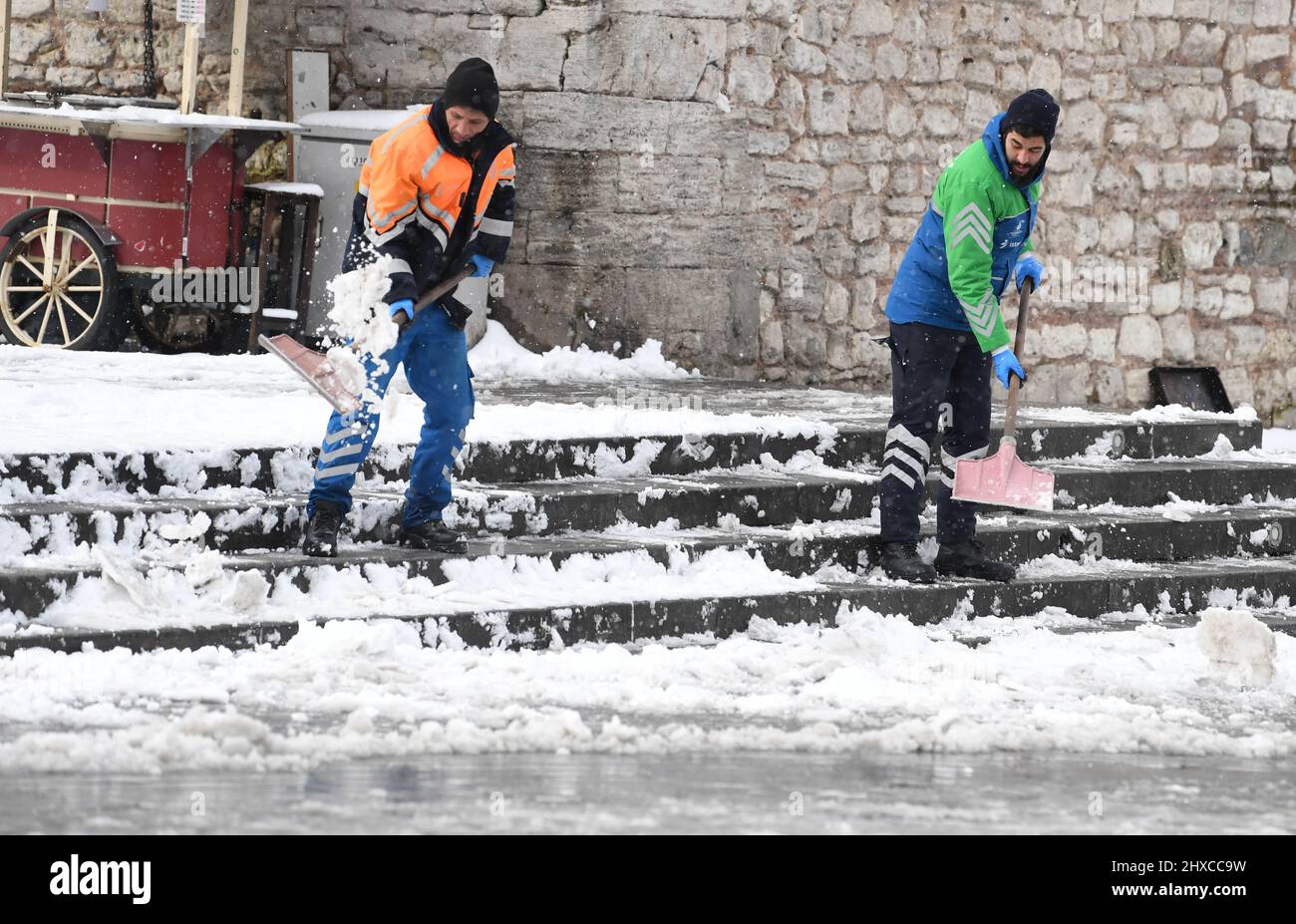 Istanbul, Turkey. 11th Mar, 2022. Men clear snow at Taksim Square in Istanbul, Turkey, March 11, 2022. A blanket of heavy snow covered Turkey's largest city Istanbul on Friday, disrupting air traffic, bringing sea and land transport to a halt, and forcing school closures. Credit: Shadati/Xinhua/Alamy Live News Stock Photo