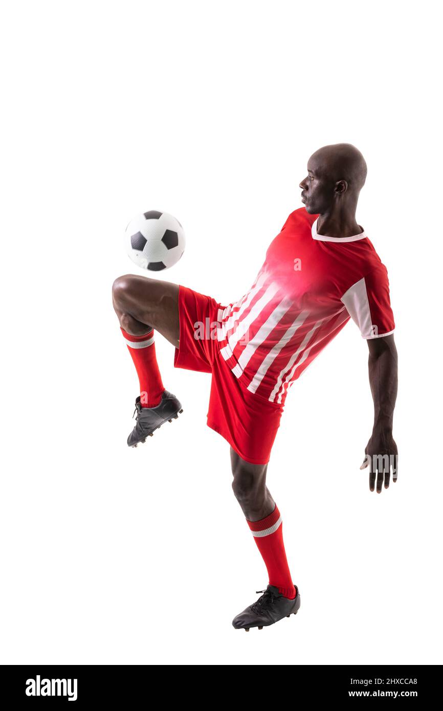 Skilled male african american soccer player kicking ball over white ...