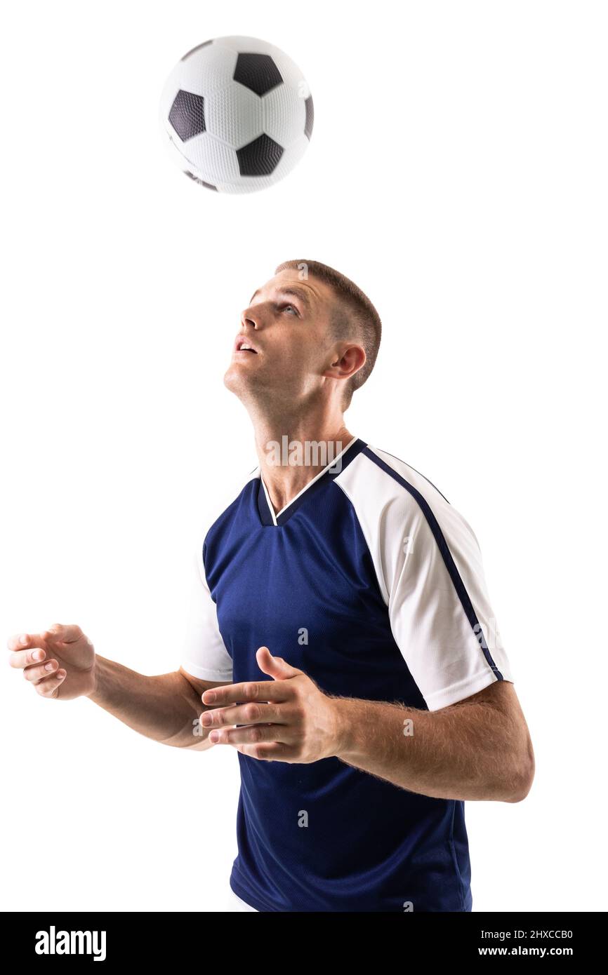 Confident skilled caucasian male athlete heading soccer ball against white background Stock Photo