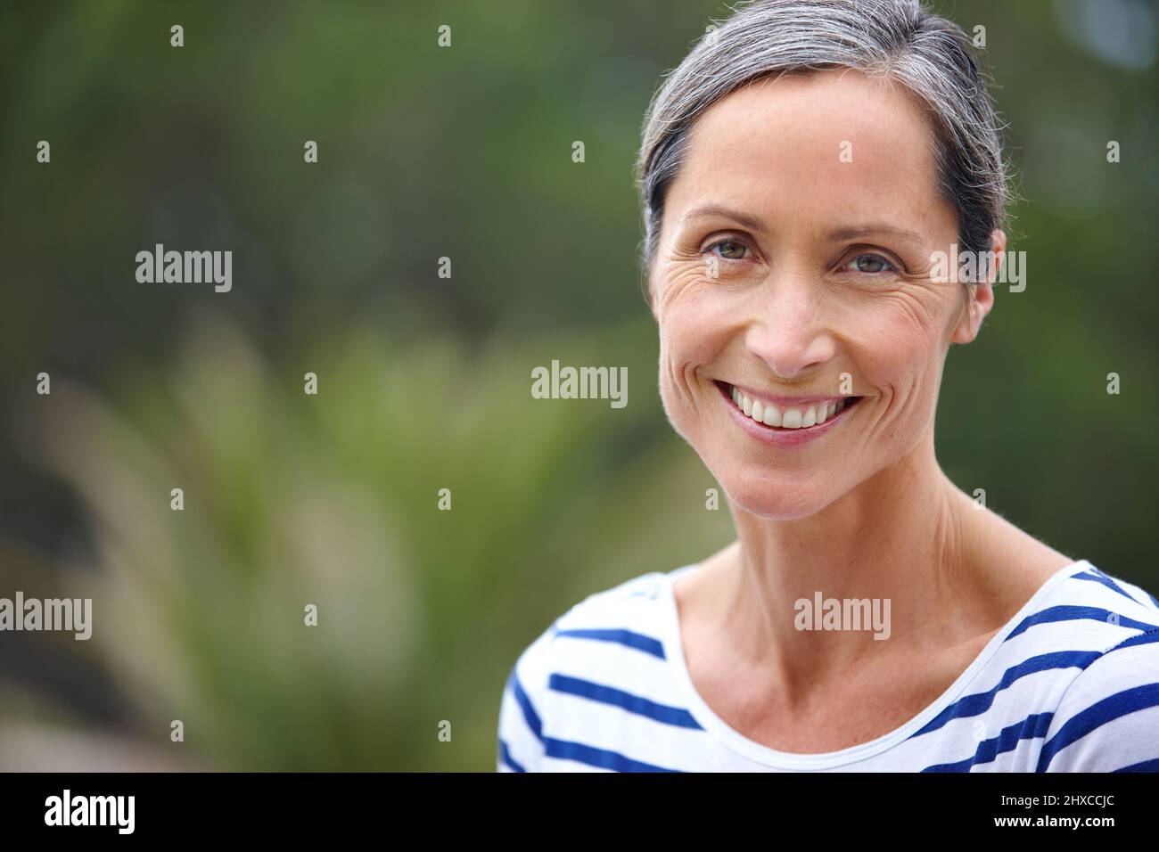 Content with her life. Cropped portrait of an attractive mature woman in casualwear standing outdoors. Stock Photo