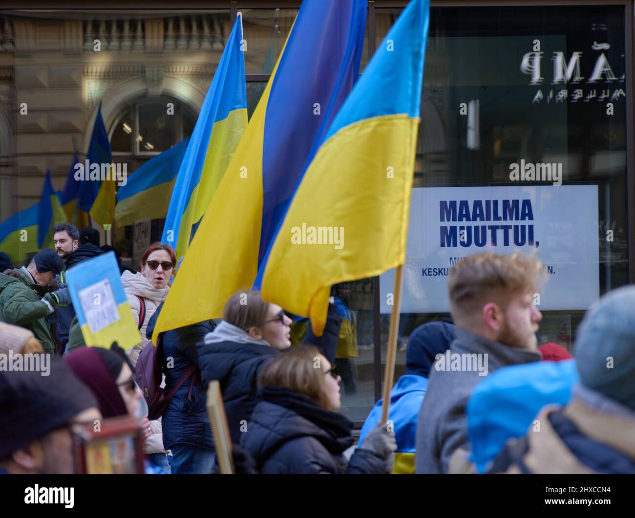 Helsinki, Finland - March 5, 2022: Demonstrators with a Ukrainian flag in a rally against Russia’s military actions and occupation of Ukraine with Maa Stock Photo