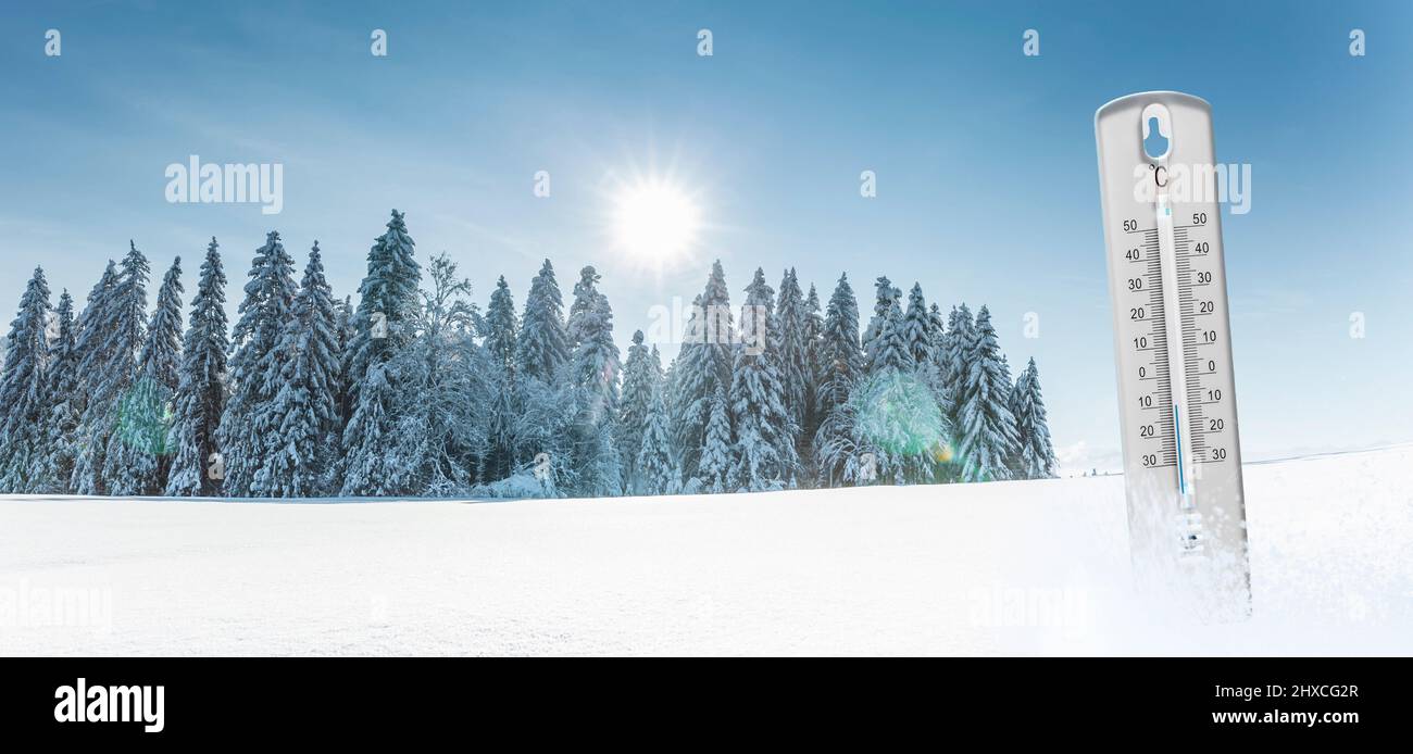 Themometer with minus temperatures in Celsius in front of a winter landscape Stock Photo