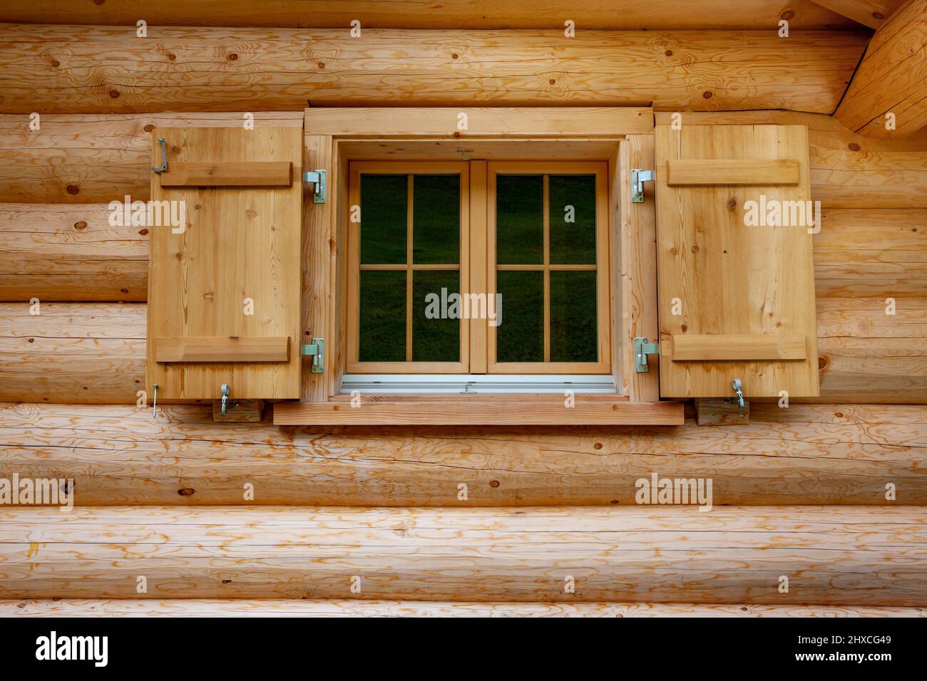 Windows in a log house from thick wooden beams hires stock photography