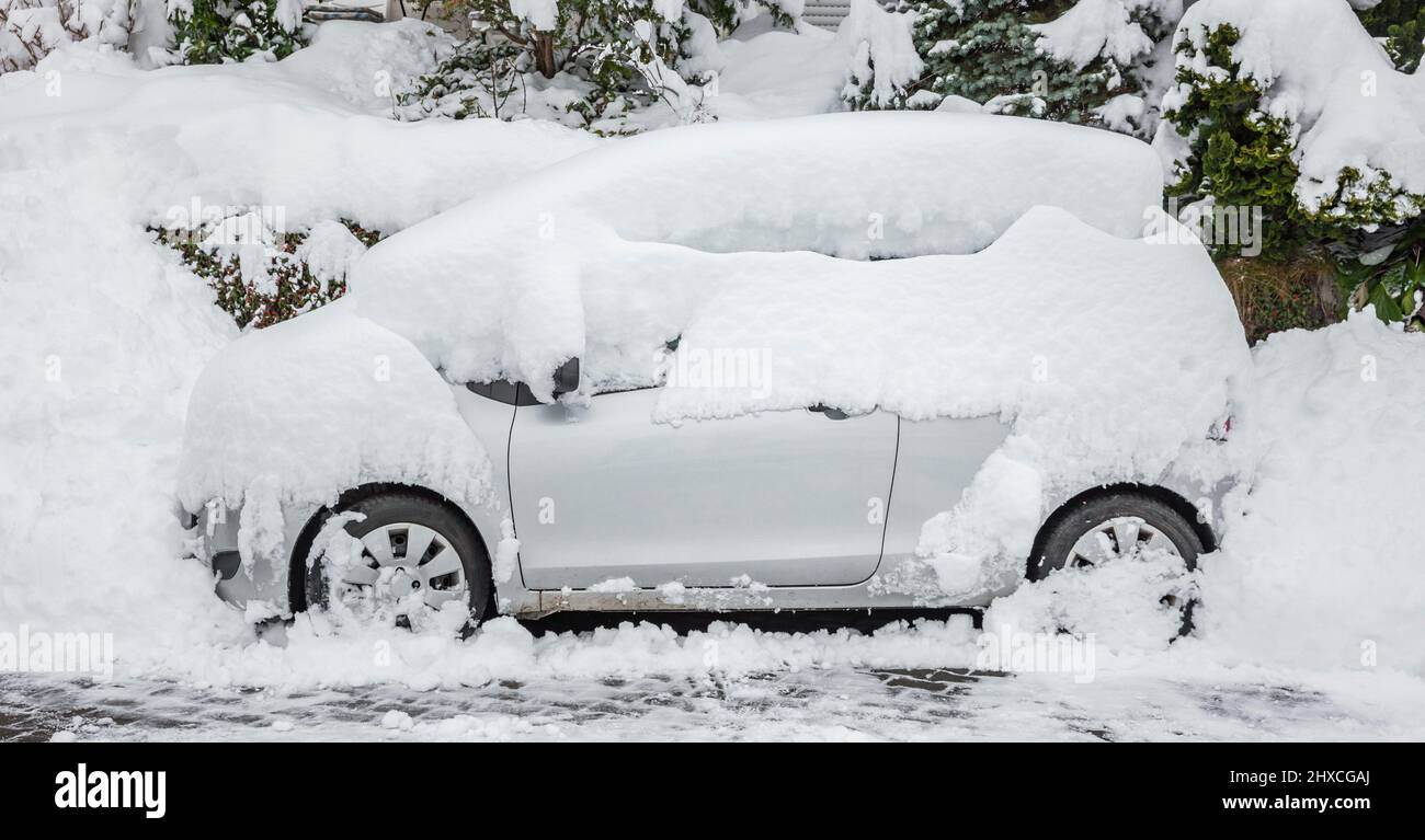 Snowbound car on the side of the road Stock Photo