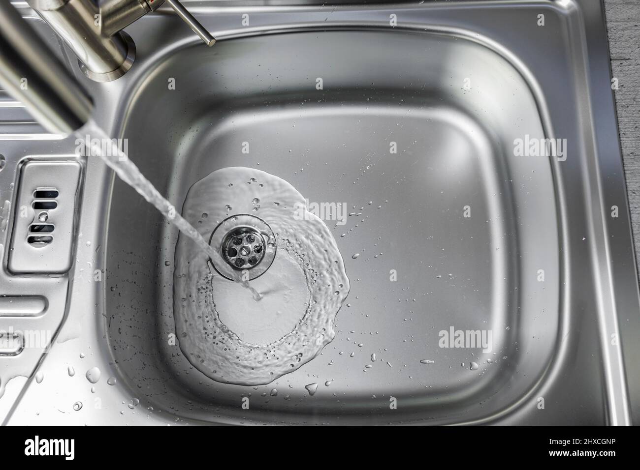 Water flows from a faucet into a sink Stock Photo Alamy