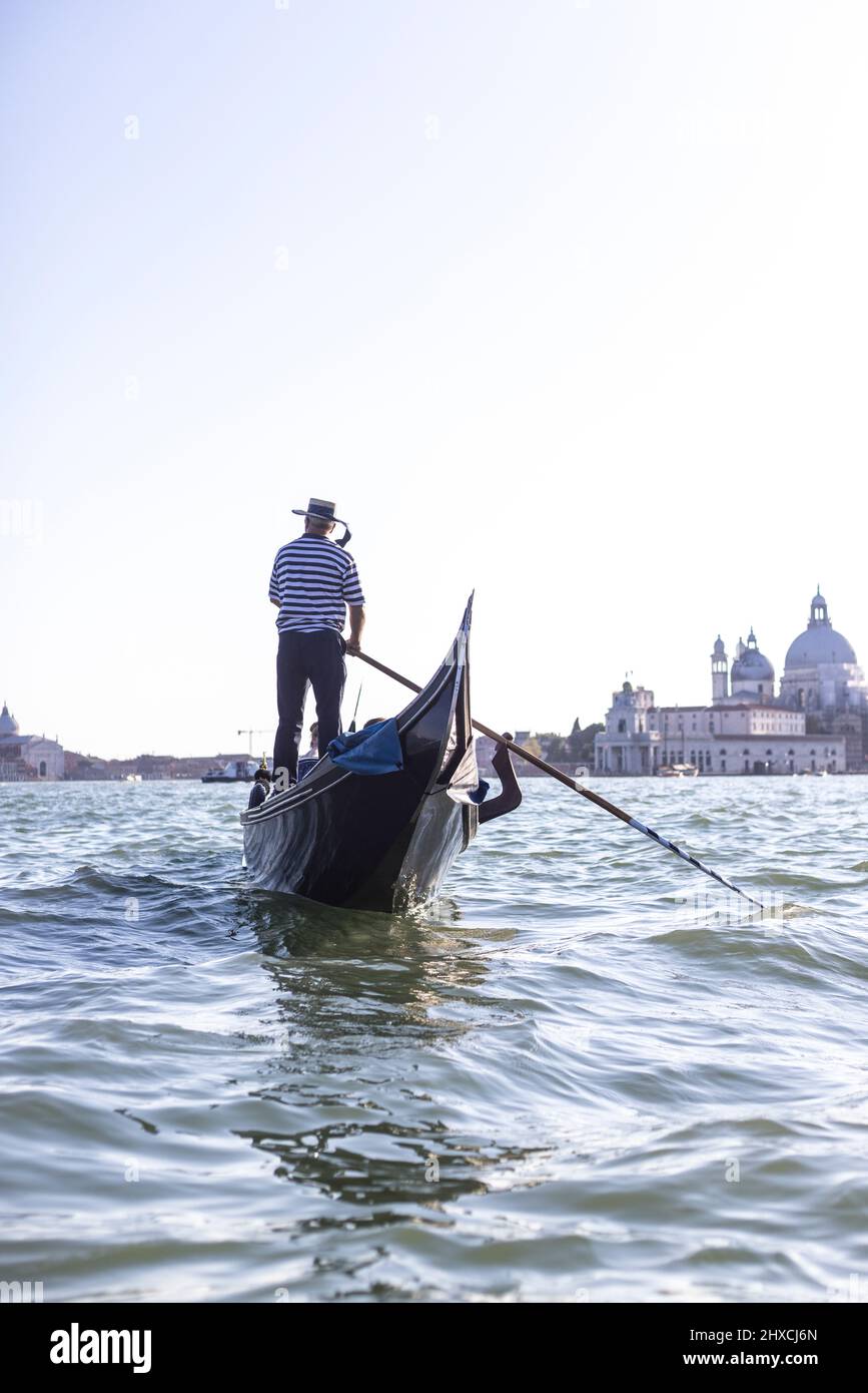 Rear view of a gondola with a gondolier in the Venice Lagoon Stock ...