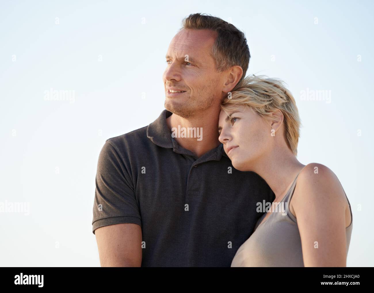 Our bond strengthens everyday. A happy couple embracing on the beach. Stock Photo