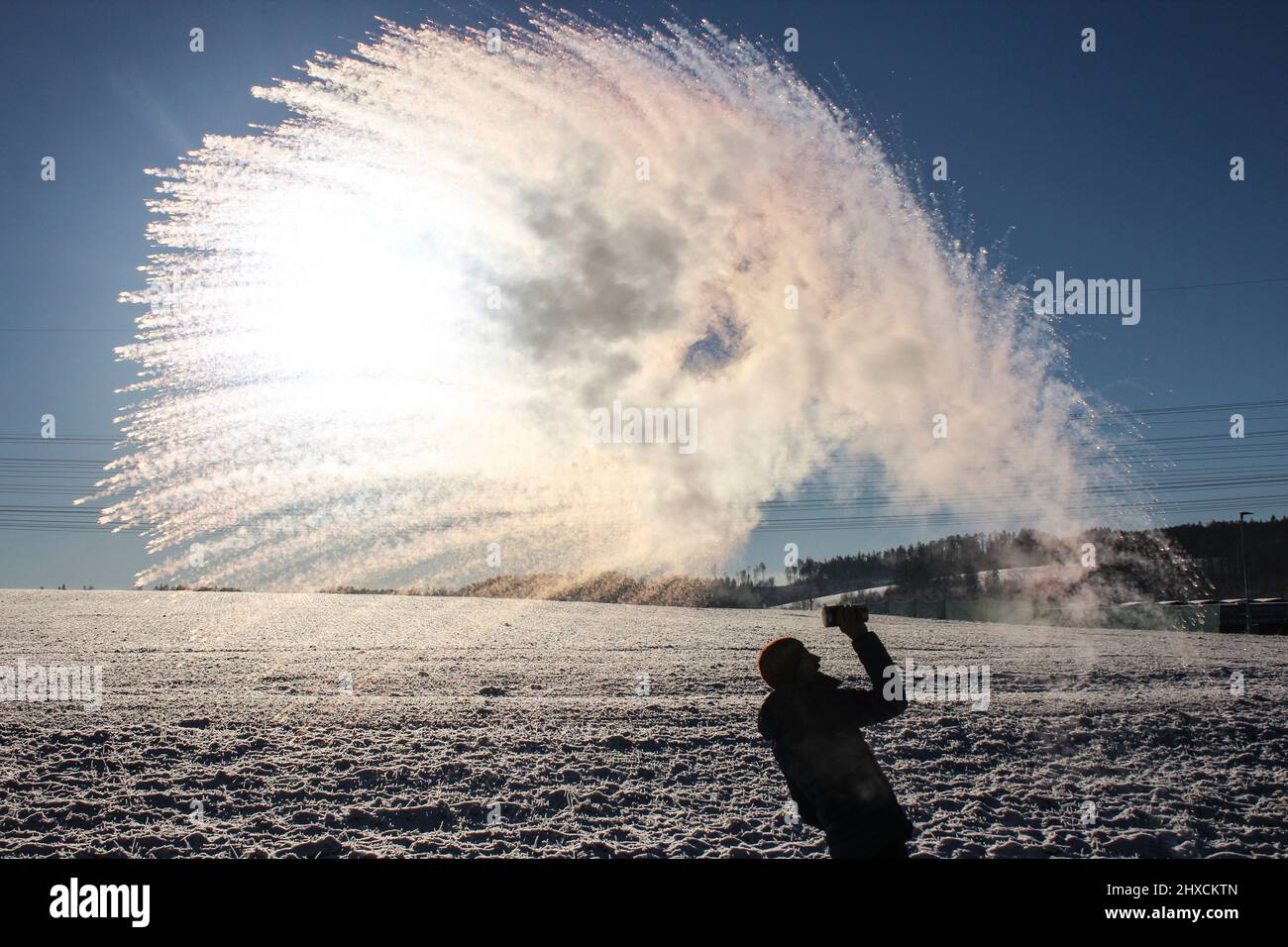Mpemba effect, boiling water is thrown into the air at sub-zero temperatures Stock Photo