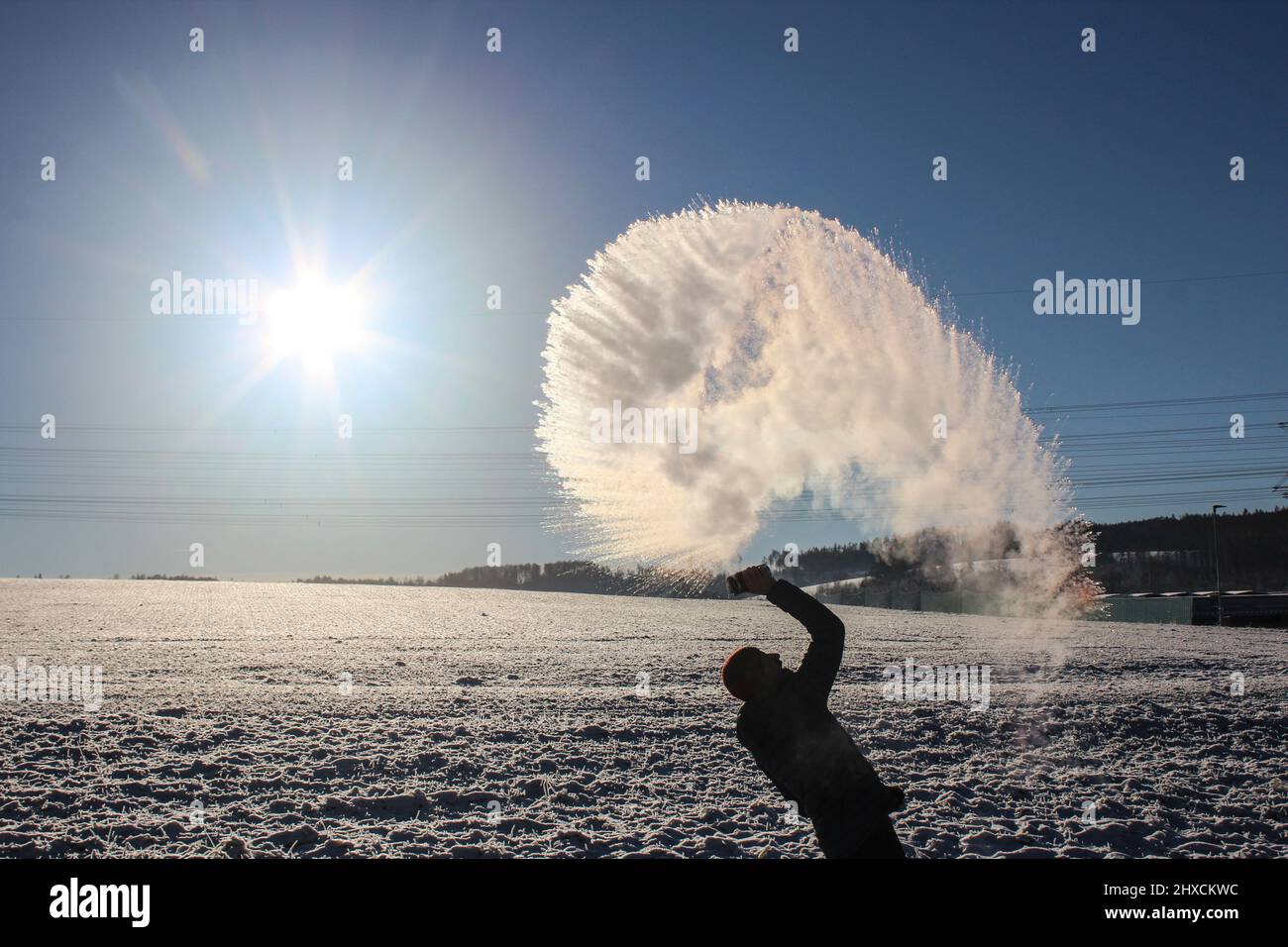 Mpemba effect, boiling water is thrown into the air at sub-zero temperatures Stock Photo