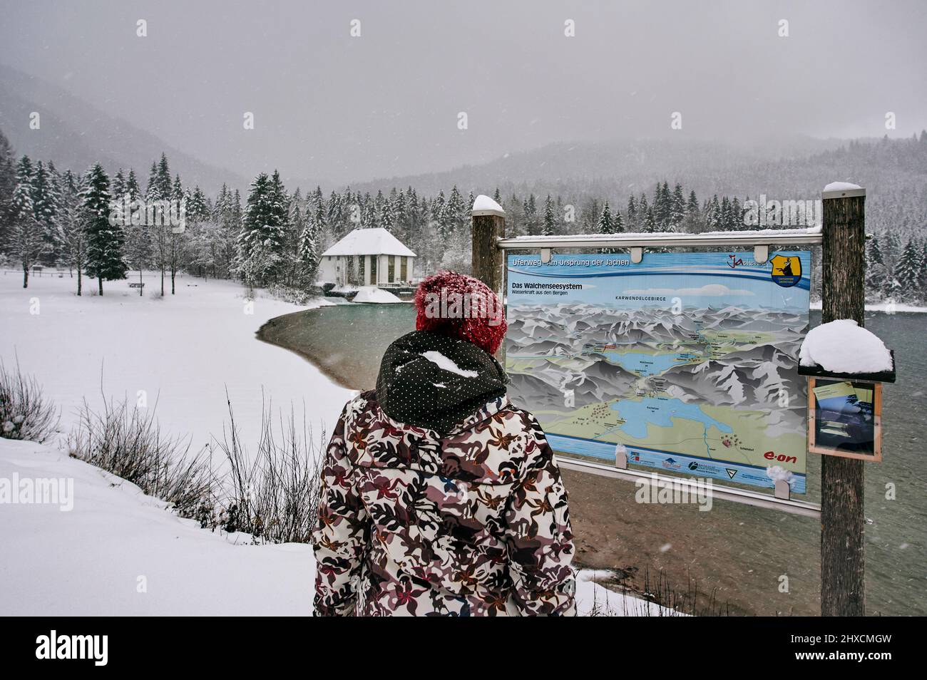Bavarian landscape in winter, Walchensee in the foothills of the Alps, tourist at the information board about the Walchensee system Stock Photo