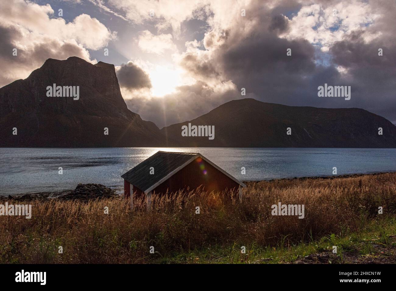 Autumn impressions from the Norwegian island Senja above the Arctic Circle, Scandinavia and Norway pure, typical for the island, the red boat houses, sun star in the backlight, Stock Photo