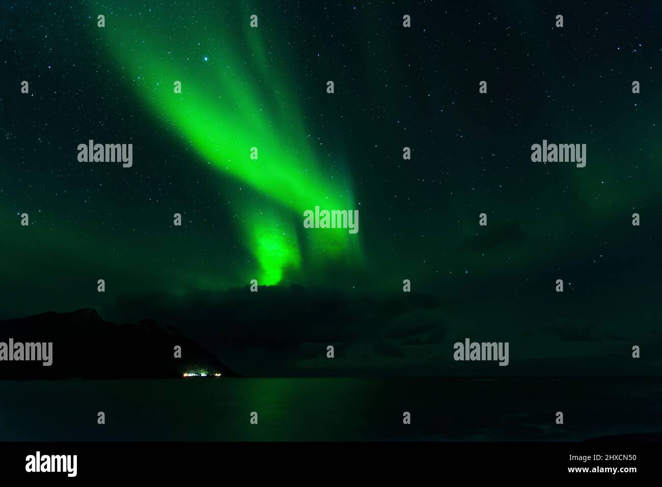 Northern lights or aurora borealis dance over the fjord landscape hi ...