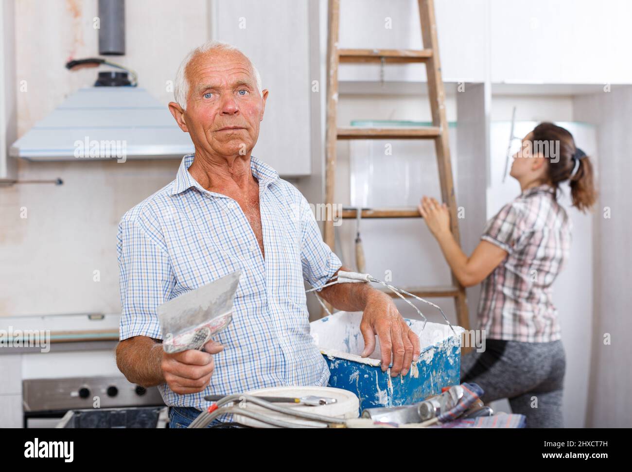 Old worker with plastering tools Stock Photo