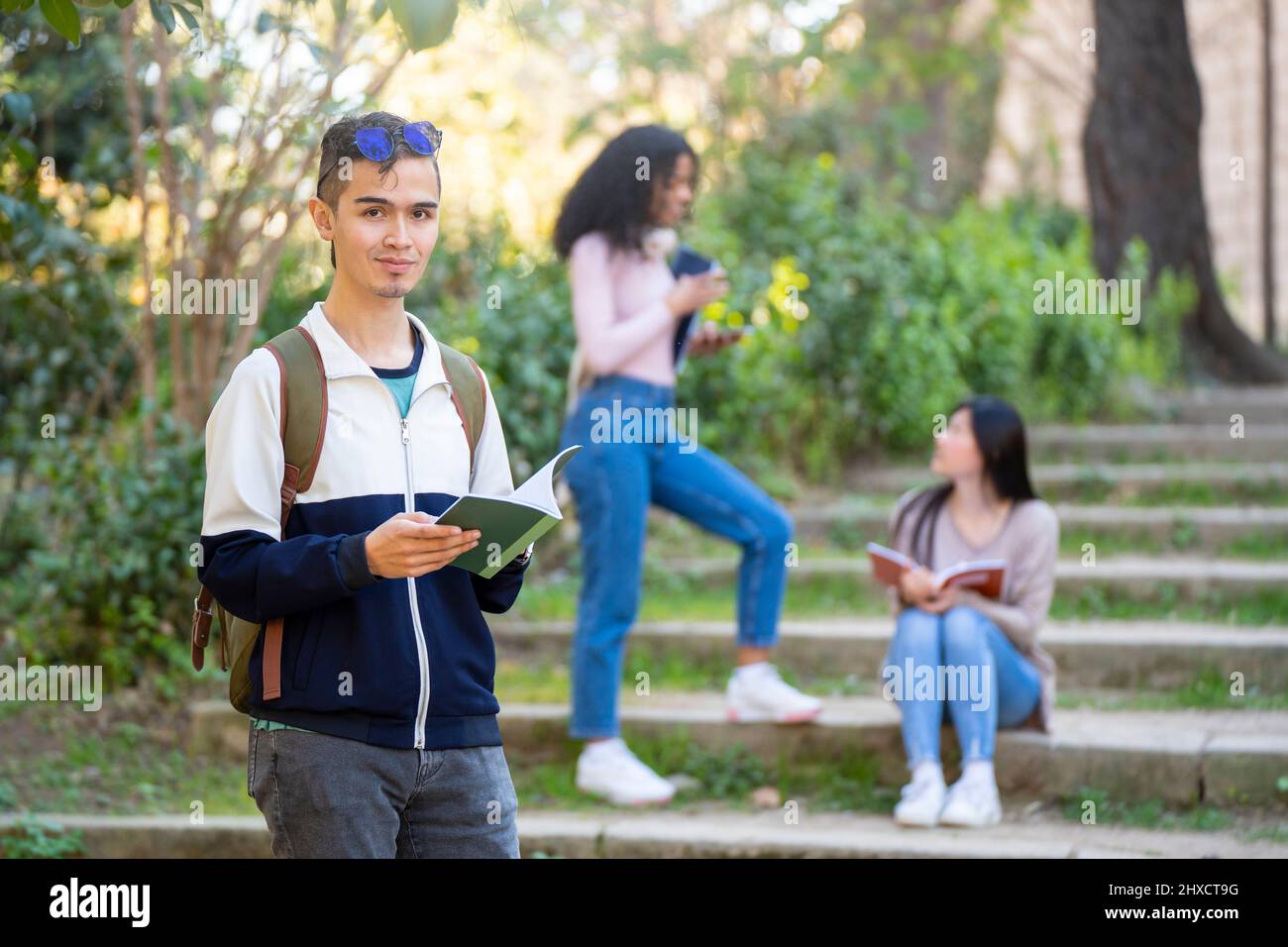Young latin student smiling and looking to the camera with a notebook Stock Photo