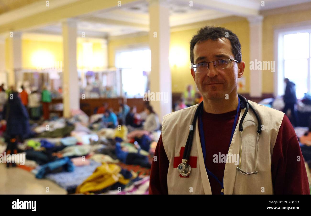 Doctor Andrea Sakhaltuyev is seen inside the VIP hall which is used as a makeshift first aid station and camp for women and children who fled the ongoing Russian invasion, at the train station in Lviv, Ukraine, March 11, 2022. Sakhalktuyev fled the invasion of Crimea in 2014 and was forced to leave Kyiv now for Lviv where he and his daughter, a medical student, work at the first aid station. REUTERS/Kai Pfaffenbach Stock Photo