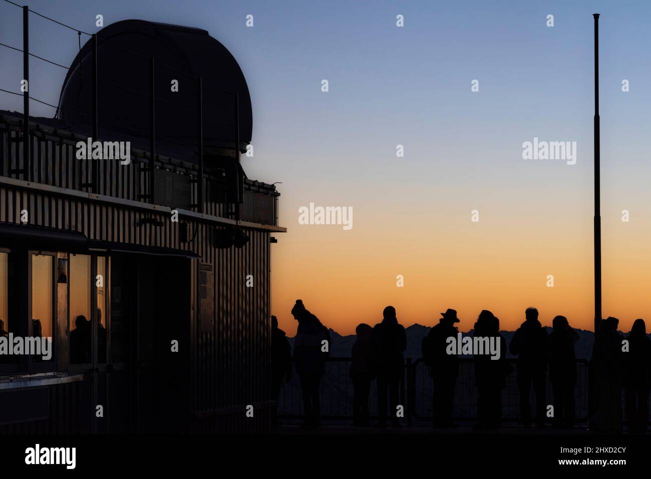 Morning atmosphere on the Zugspitze, sunrise on Germany's highest mountain 'Top of Germany'. Early risers wait until the sun shows itself. Stock Photo