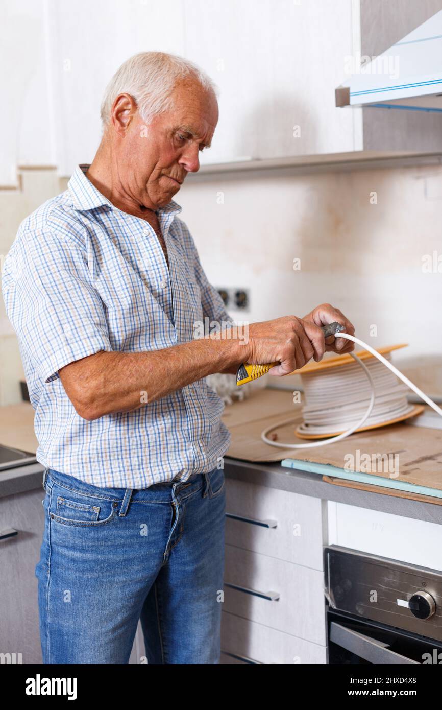 Senior man working on apartment overhauls Stock Photo