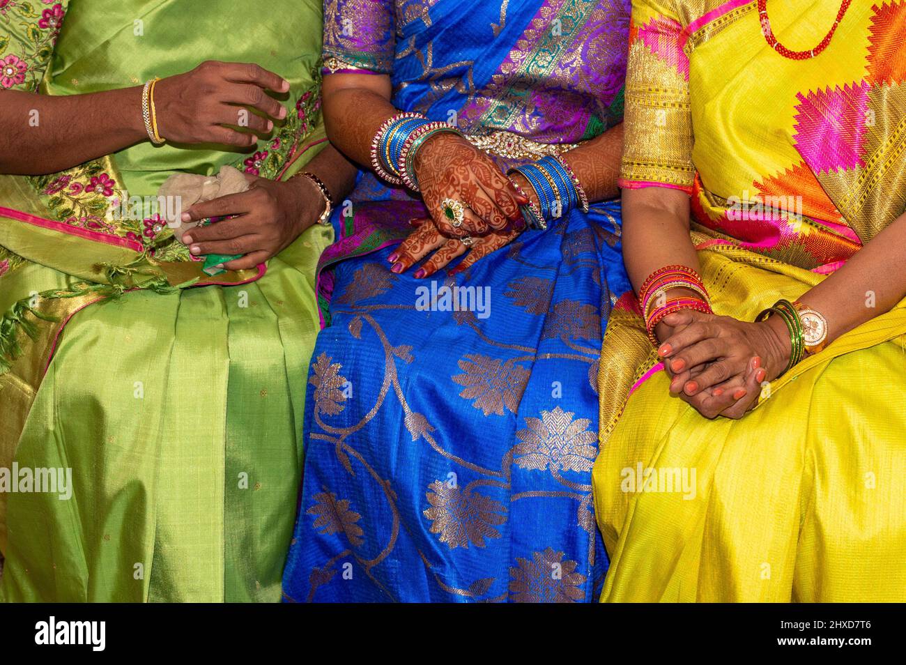 Women with jewelry and colorful sarees during an Indian wedding