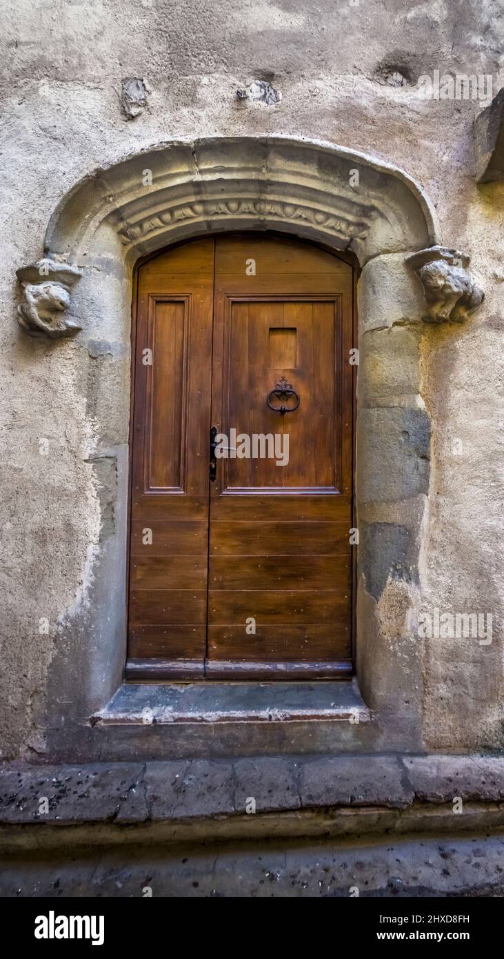 Old front door in Aigne. The old village center has the shape of a snail shell and was built in the 11th century. Stock Photo