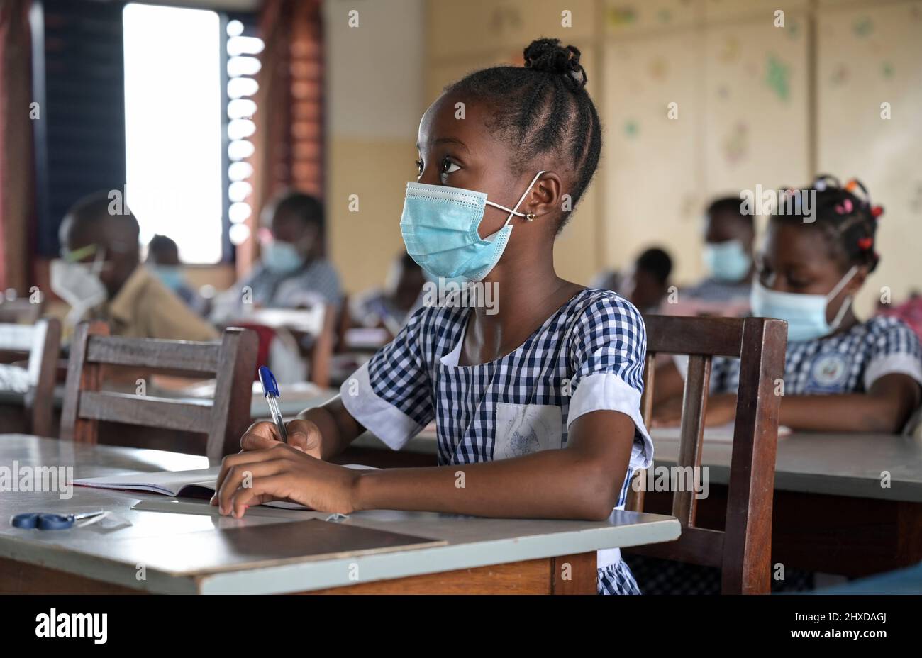 IVORY COAST, Abidjan, catholic school, Corona times, pupil with face mask / ELFENBEINKUESTE, Abidjan, Stadtteil Koumassi-Remblais, Foyer Marie Dominique von den Soeurs Salesiennes de Don Bosco / Filles Marie Auxiliatrice (FMA), Schule für Kinder in der Corona Zeit mit Masken Stock Photo