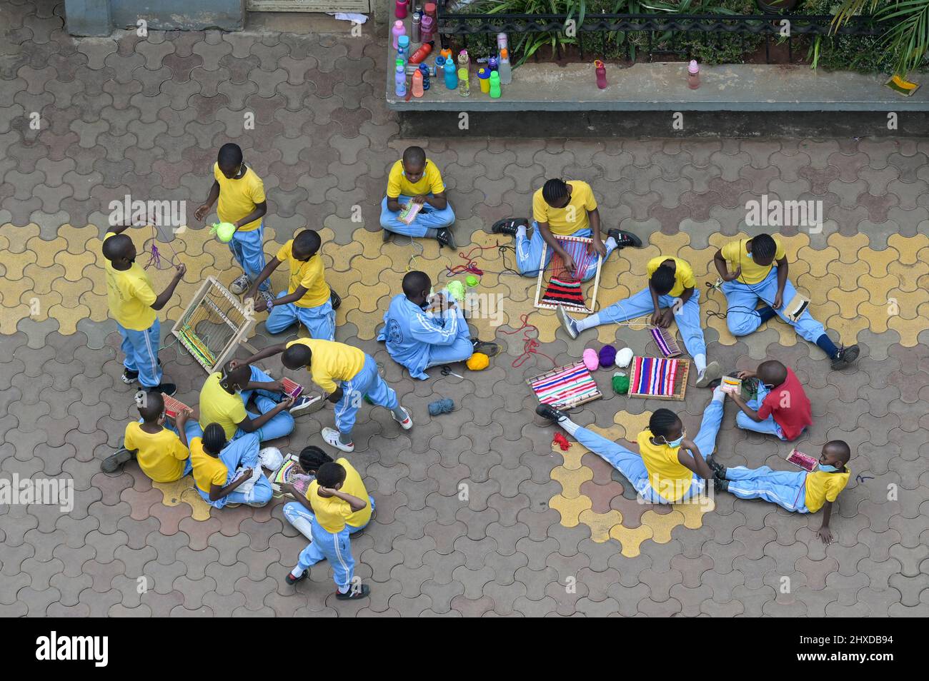 KENYA, Nairobi, school children weaving at schoolyard / KENIA, Nairobi, Schulkinder in Sportkleidung, Webrahmen Stock Photo
