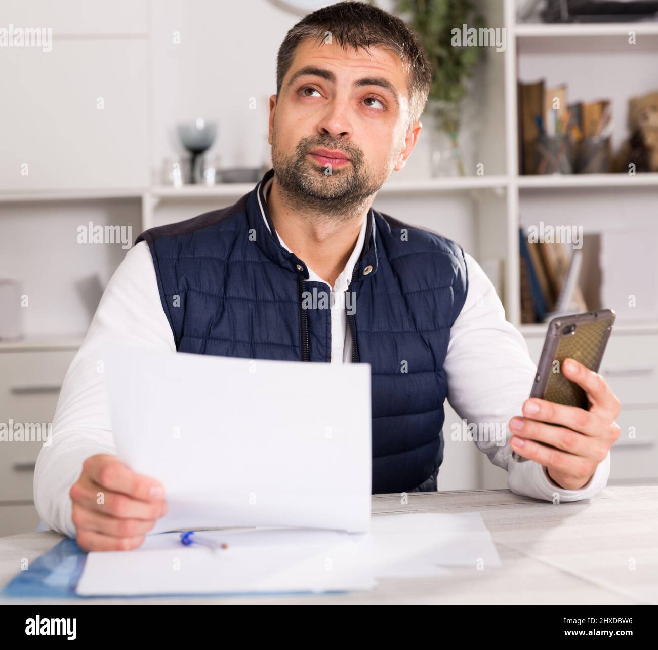Male business working with documents, holding mobile Stock Photo