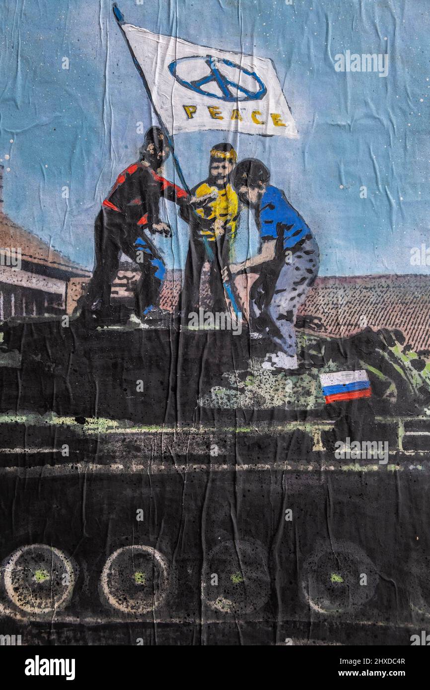 Barcelona, Catalonia, Spain. 11th Mar, 2022. Three children are seen placing a flag for peace in Ukraine on a Russian tank in the new collage by artist TvBoy in Plaza de Sant Jaume. TvBoy, the Italian artist living in Barcelona, installs a new collage on the war in Ukraine in Plaza de Sant Jaume, representing three children installing a flag of peace on a Russian tank. (Credit Image: © Paco Freire/SOPA Images via ZUMA Press Wire) Credit: ZUMA Press, Inc./Alamy Live News Stock Photo
