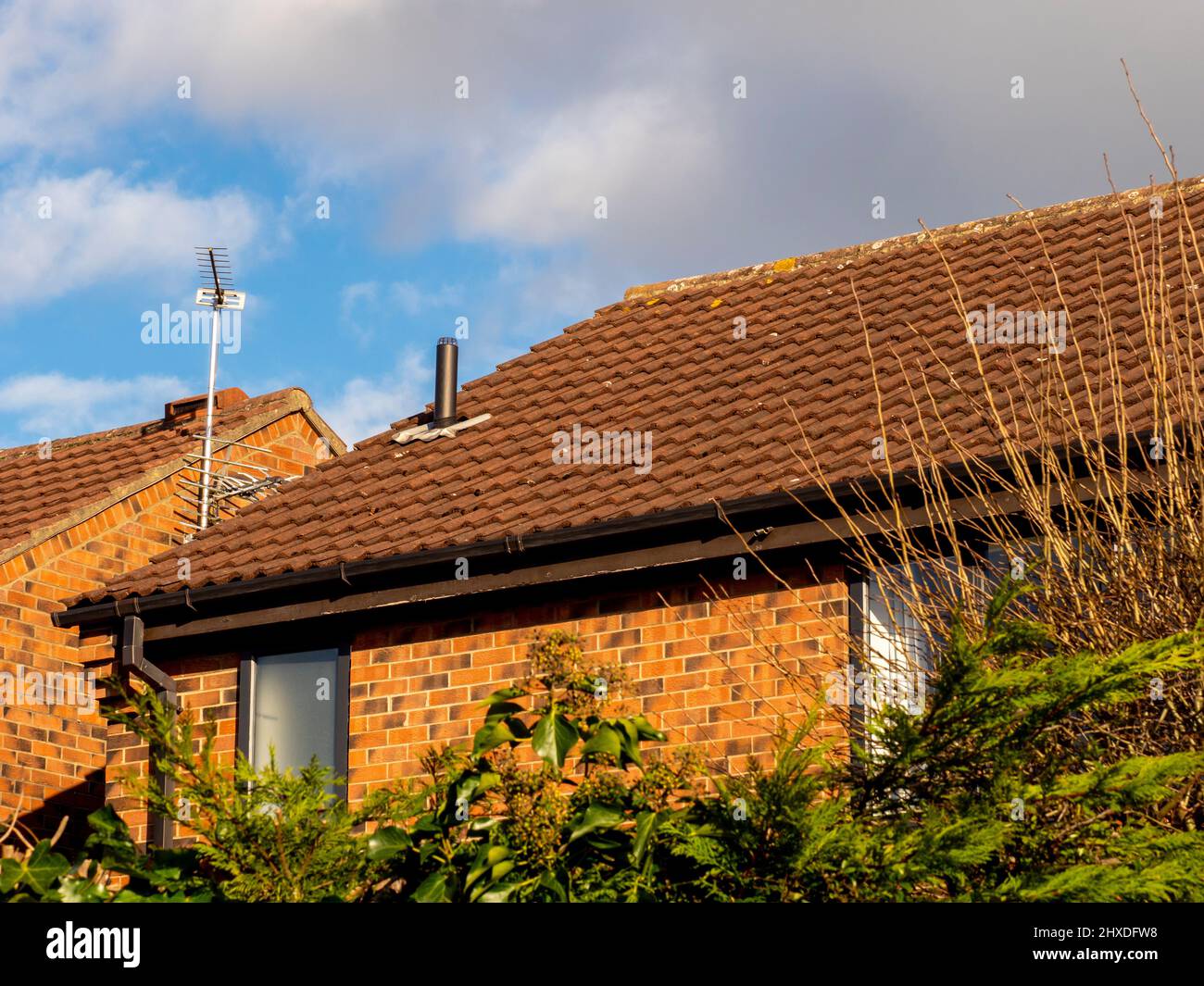Typical domestic tiled house roof with Vent pipe protruding through tiles. Stock Photo