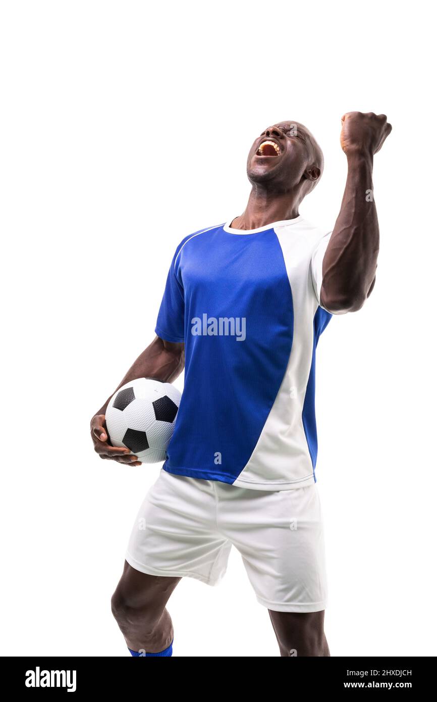 Young african american soccer player holding ball celebrating goal over white background Stock Photo