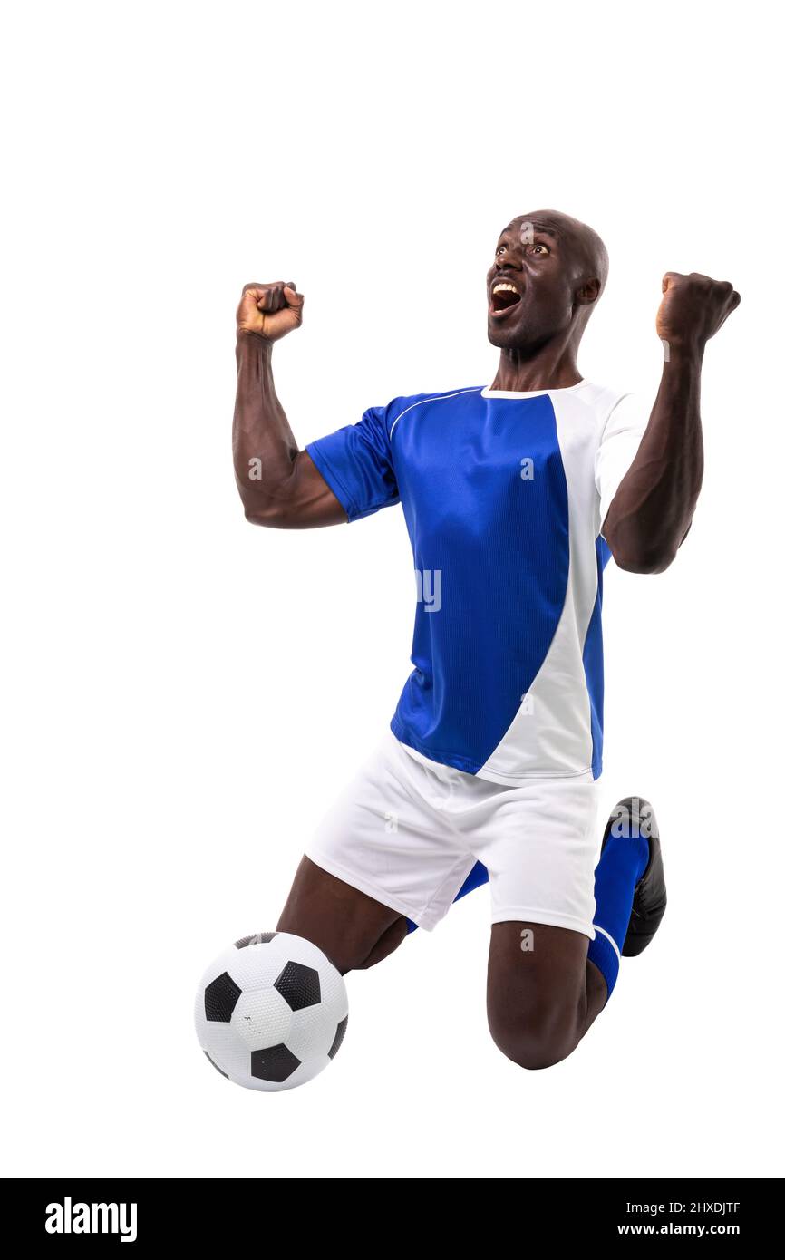 Excited male african american soccer athlete kneeling while celebrating goal over white background Stock Photo