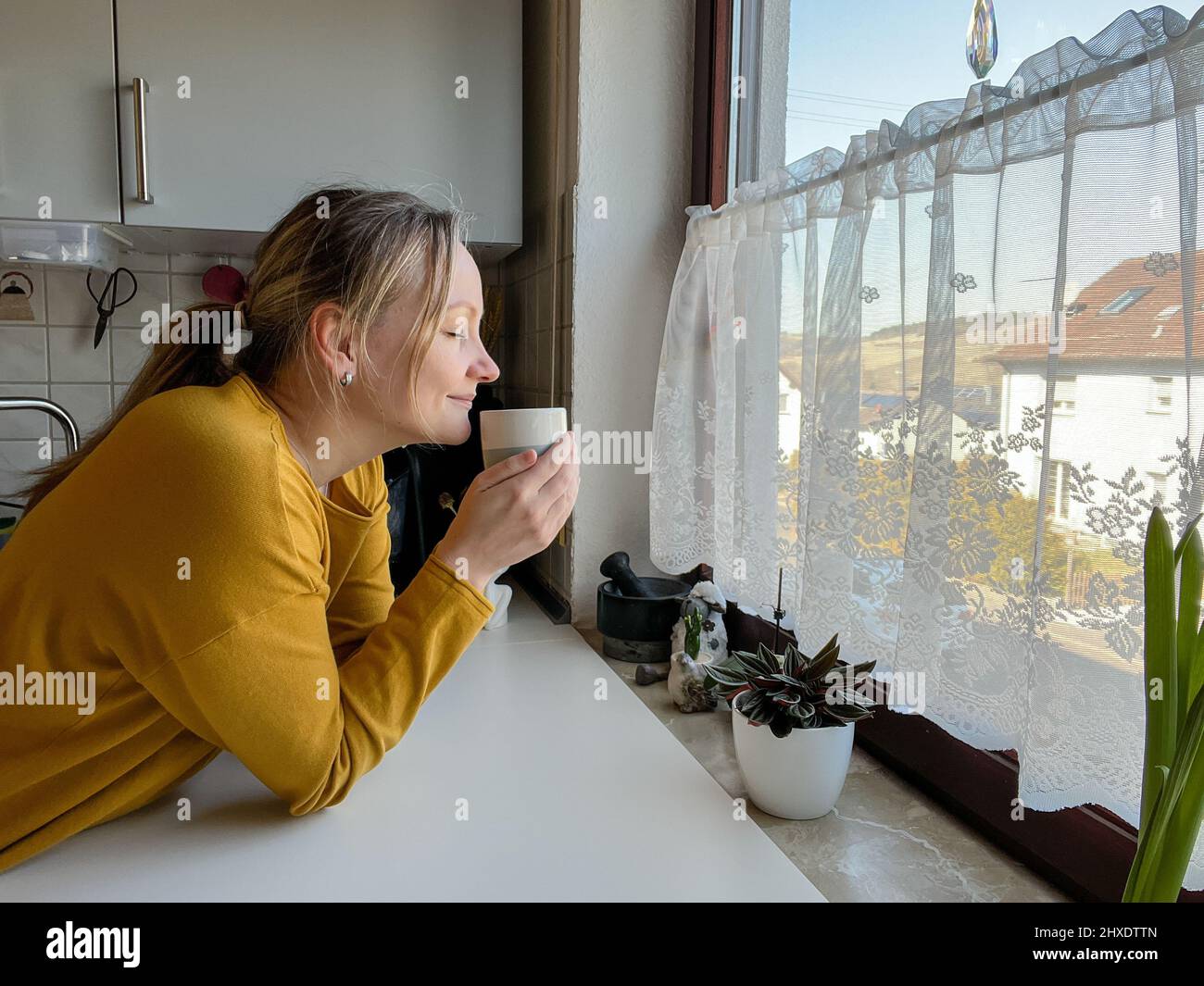 Woman is holding a cup and smelling the drink Stock Photo