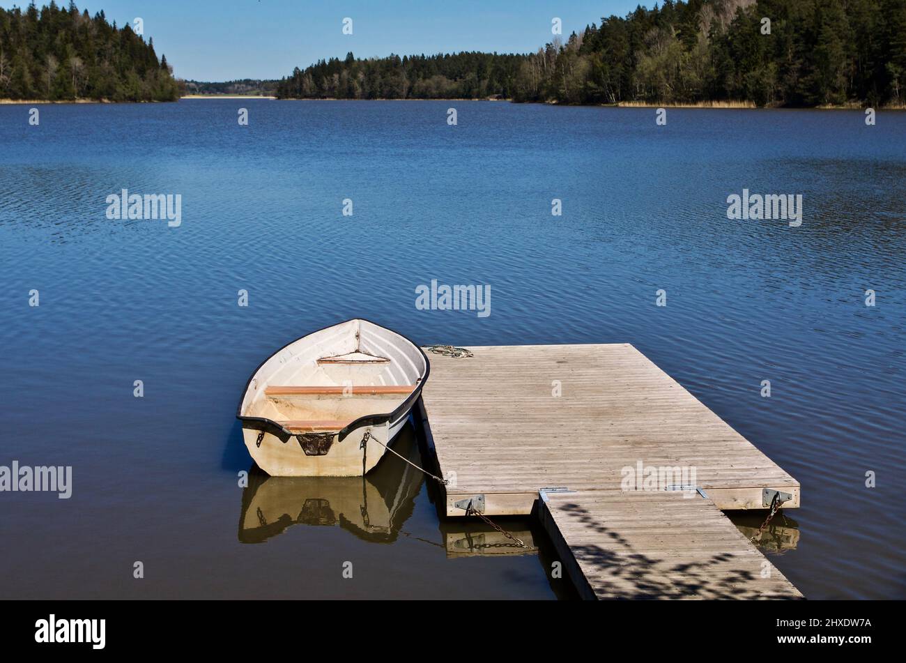 Small white boat moored at a jetty in the Baltic Sea. Stock Photo