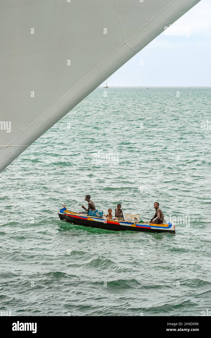 Madagascar fishermen in their dugout canoe in fascination at the bow of a cruise ship, Toliara, Madagascar Island Stock Photo