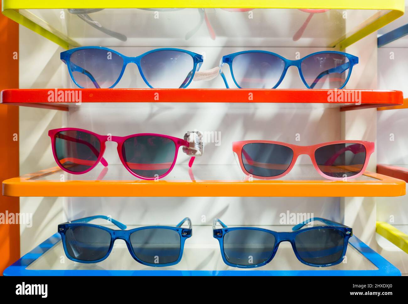 Beautiful multi-color sunglasses in modern optic shop. Several trendy stylish glasses. Stock Photo