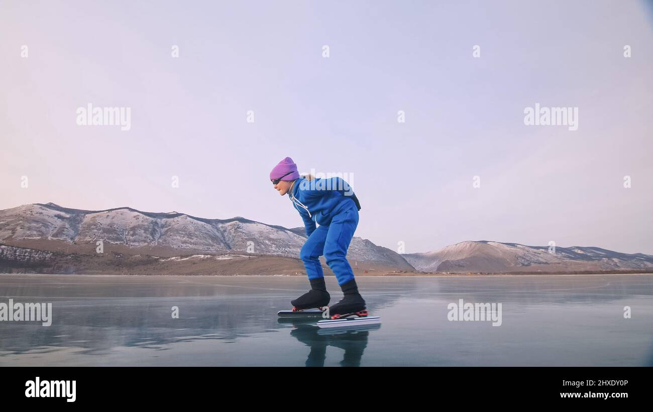 The child train on ice professional speed skating. The girl skates in
