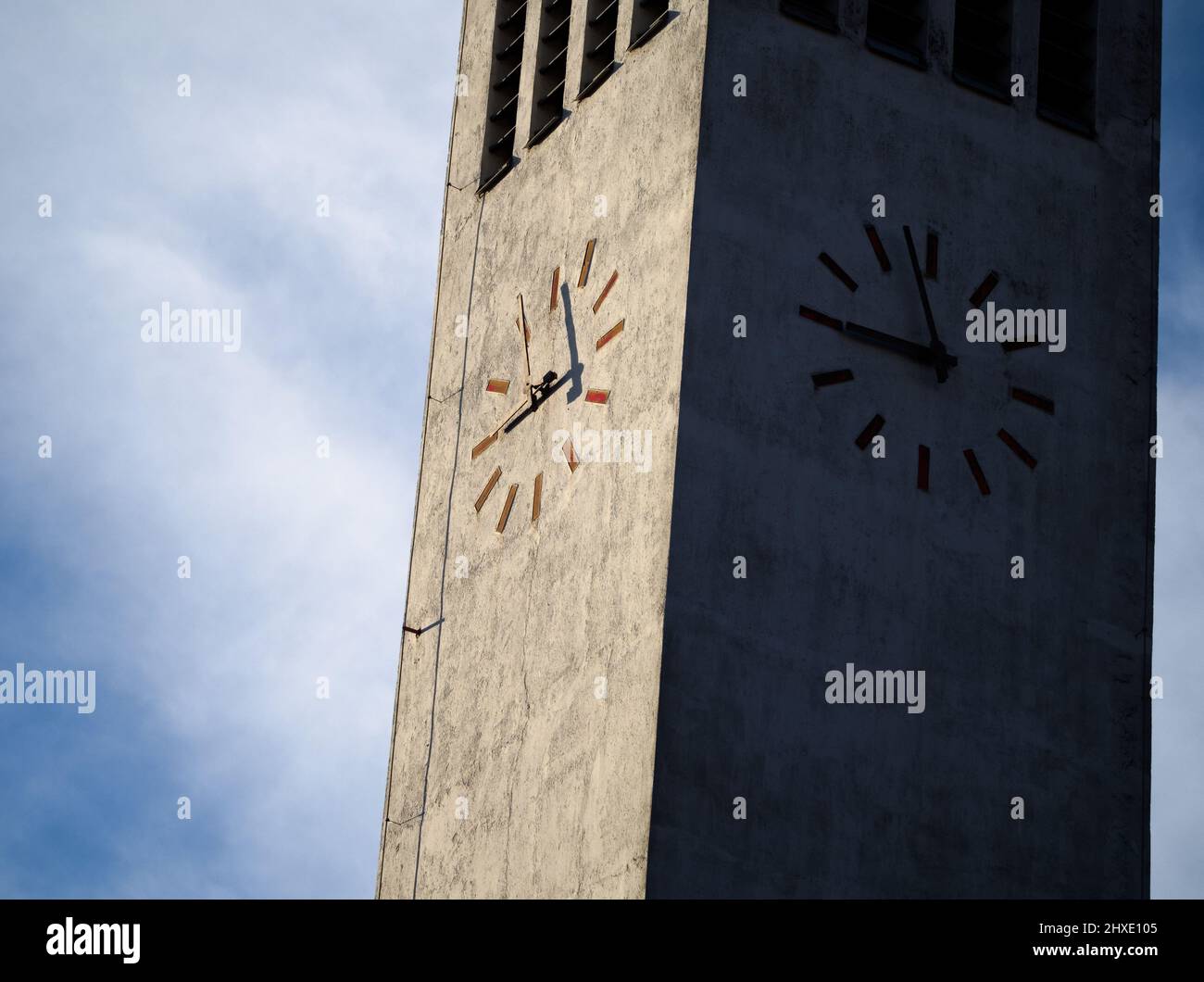 Modern Minimalist Tower Clock Closeup with Overcast Sky Stock Photo