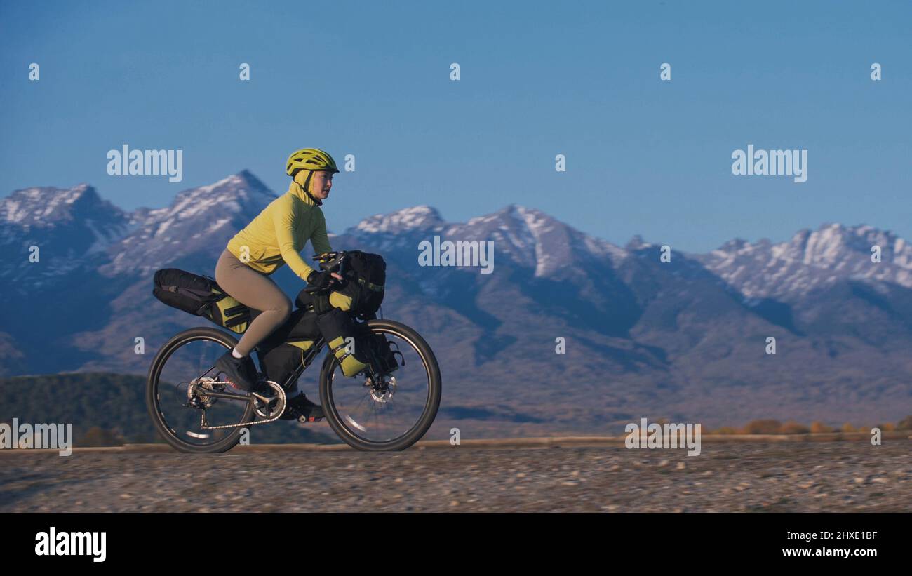 The woman travel on mixed terrain cycle touring with bikepacking. The traveler journey with bicycle bags. Sport tourism bikepacking, bike, sportswear Stock Photo