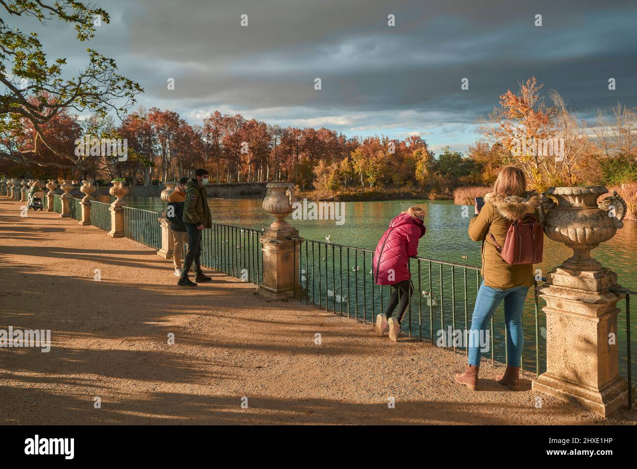 woman taking a photo of a girl who is looking at the ducks of the Tagus river in the viewpoint of the Parterre garden in Aranjuez, Madrid, Spain. Stock Photo