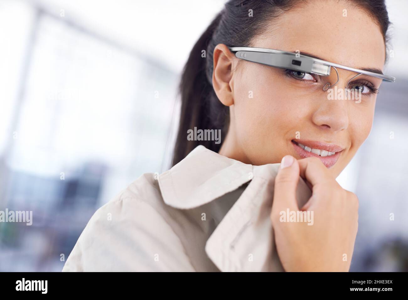 The future is now. Cropped portrait of an attractive young businesswoman using smartglasses in her office. Stock Photo