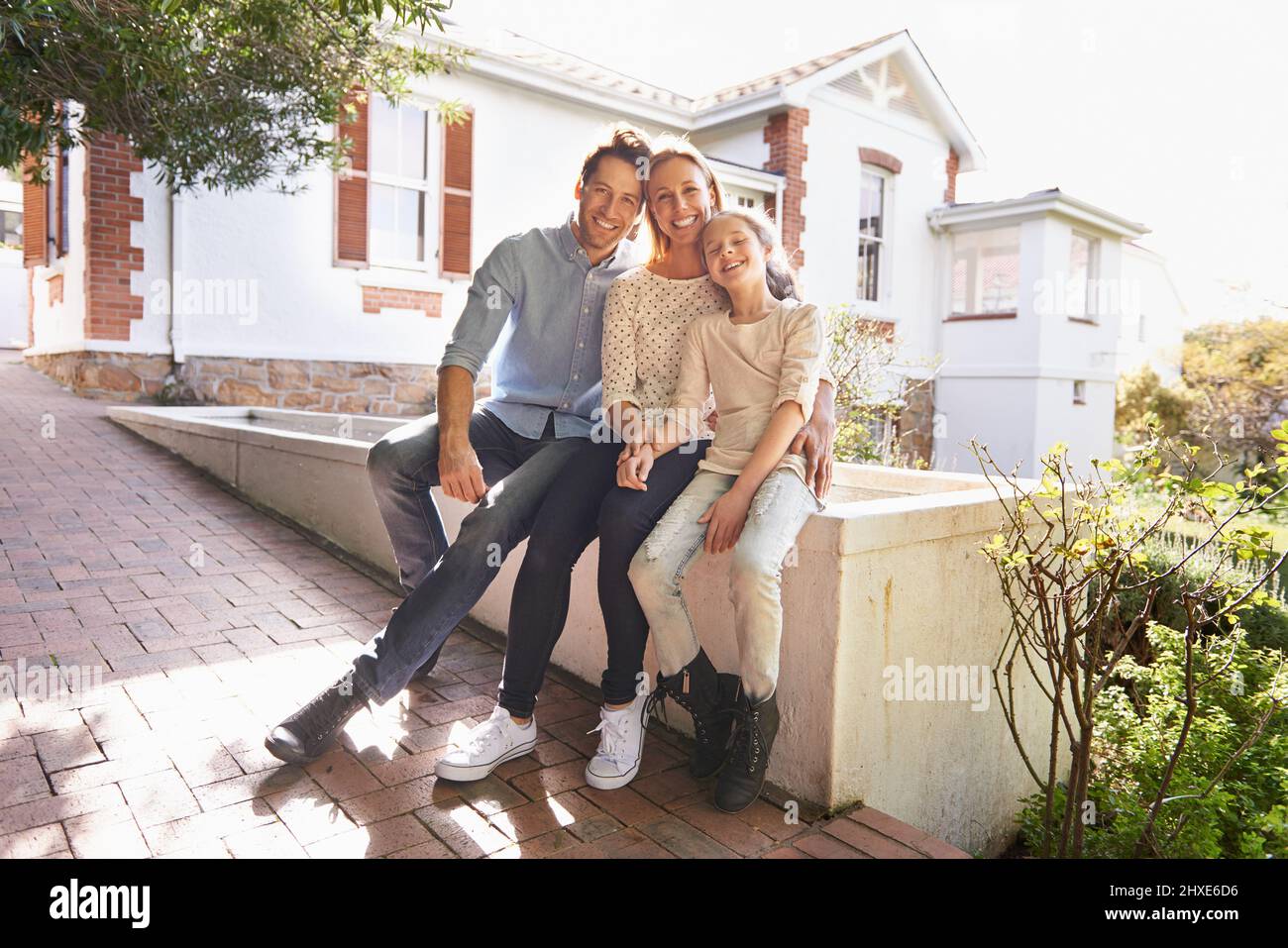 My family is my home. A portrait of a happy family sitting outside of their home. Stock Photo