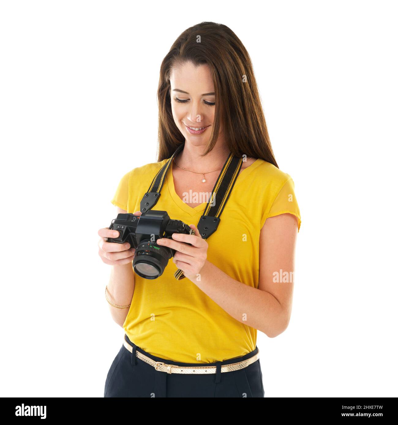 Shes quite impressed with the shots she got. Shot of a young woman holding her camera against a white background. Stock Photo