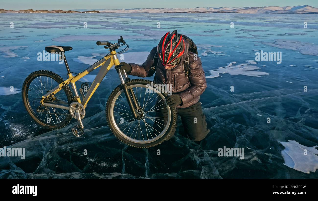Man is riding bicycle on the ice. Ice of the frozen Lake Baikal. Rider