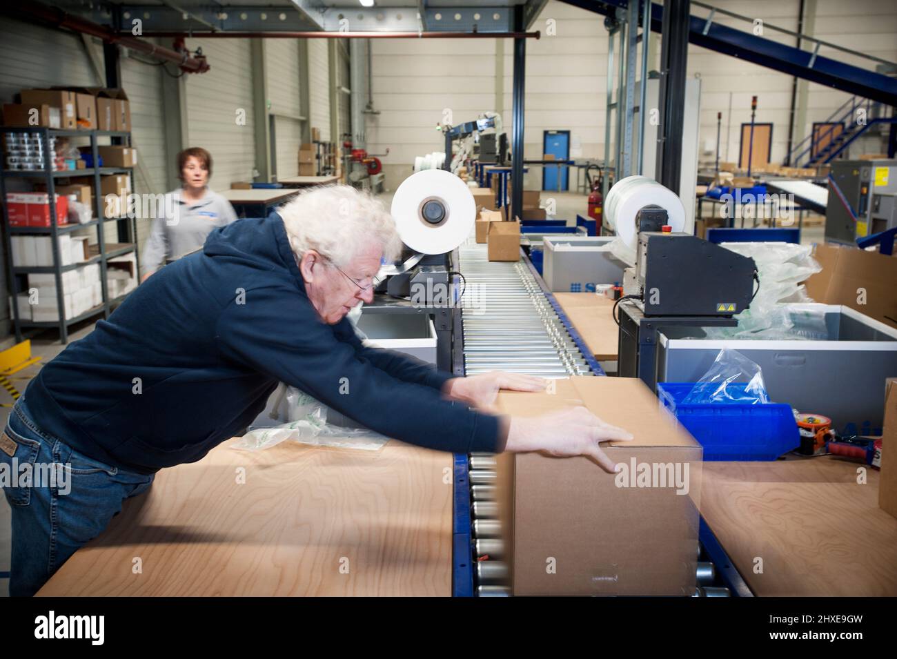 Man packaging a client order in a warehouse. Stock Photo