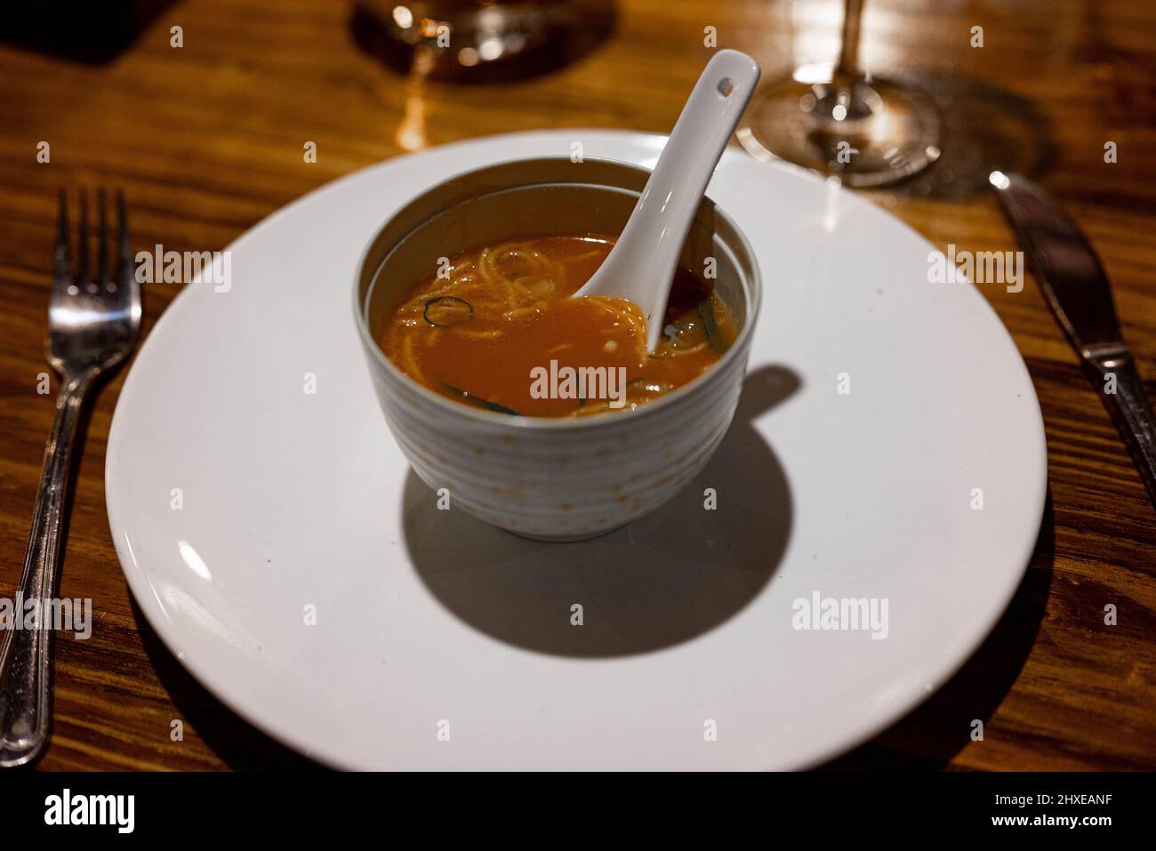 Chinese vegetarian tomato soup in traditional soup bowl on a table in a restaurant Stock Photo