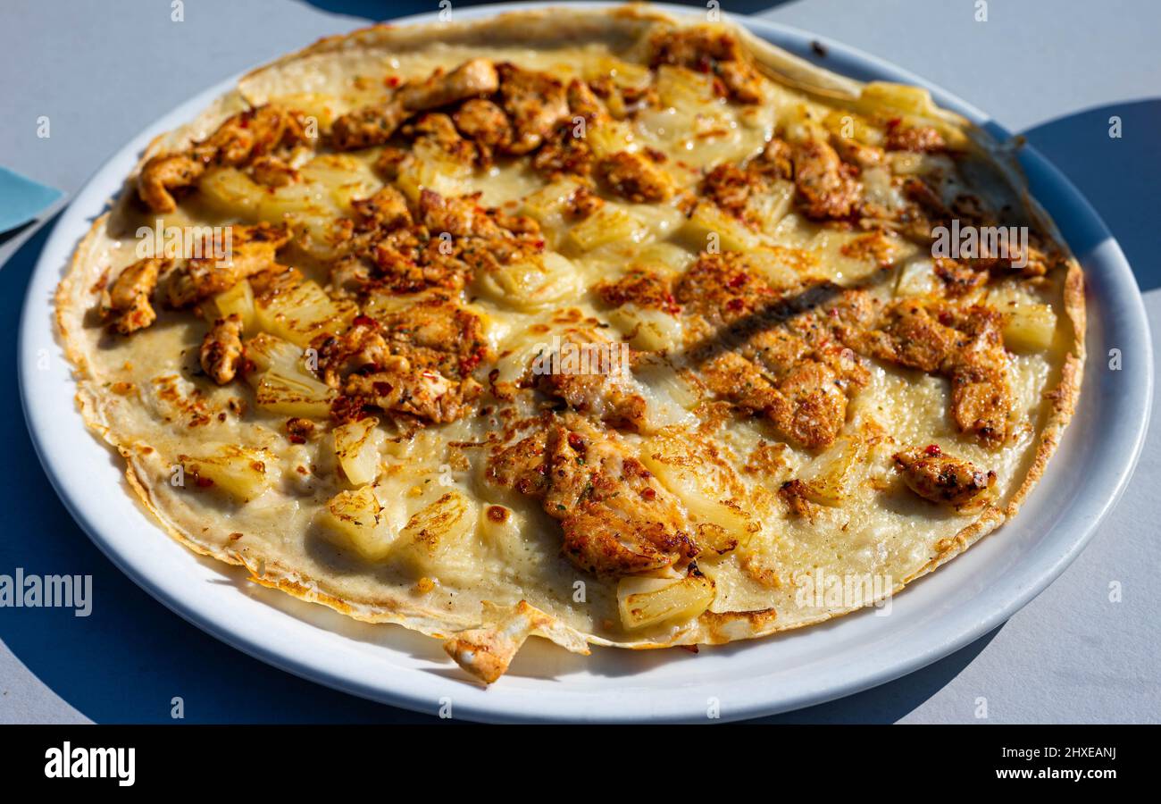 Savory piri piri pancake with pineapple and grilled seasoned chicken served in a restaurant Stock Photo