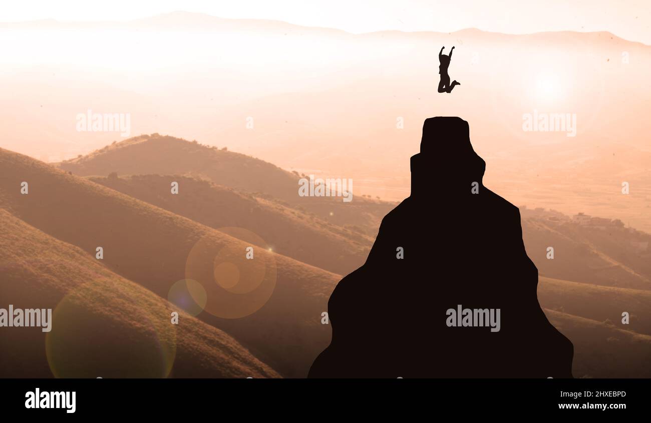 silhouette of a young woman jumping on the top of the mountain celebrating Success. Business Women Goal achievement Concept Stock Photo
