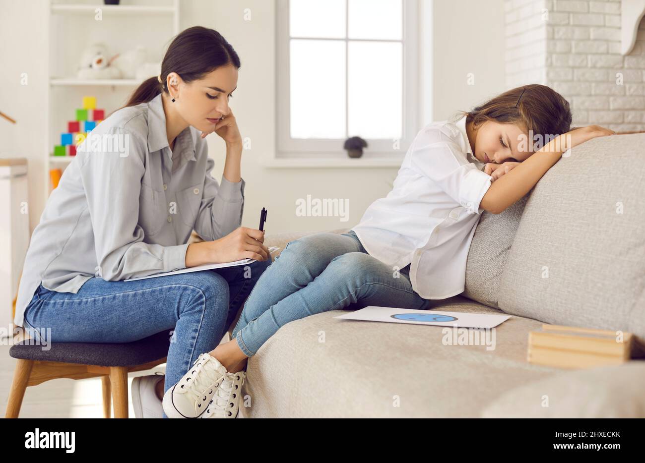 Children's psychologist or therapist helping sad girl cope with stress and problems Stock Photo
