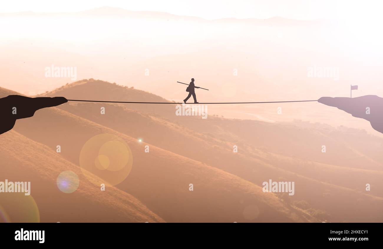 Businessman Balancing On Rope Between two Maintains Cliff At Sunset. Business Man Challenge, Goal Achievement, risk and Ambition Stock Photo