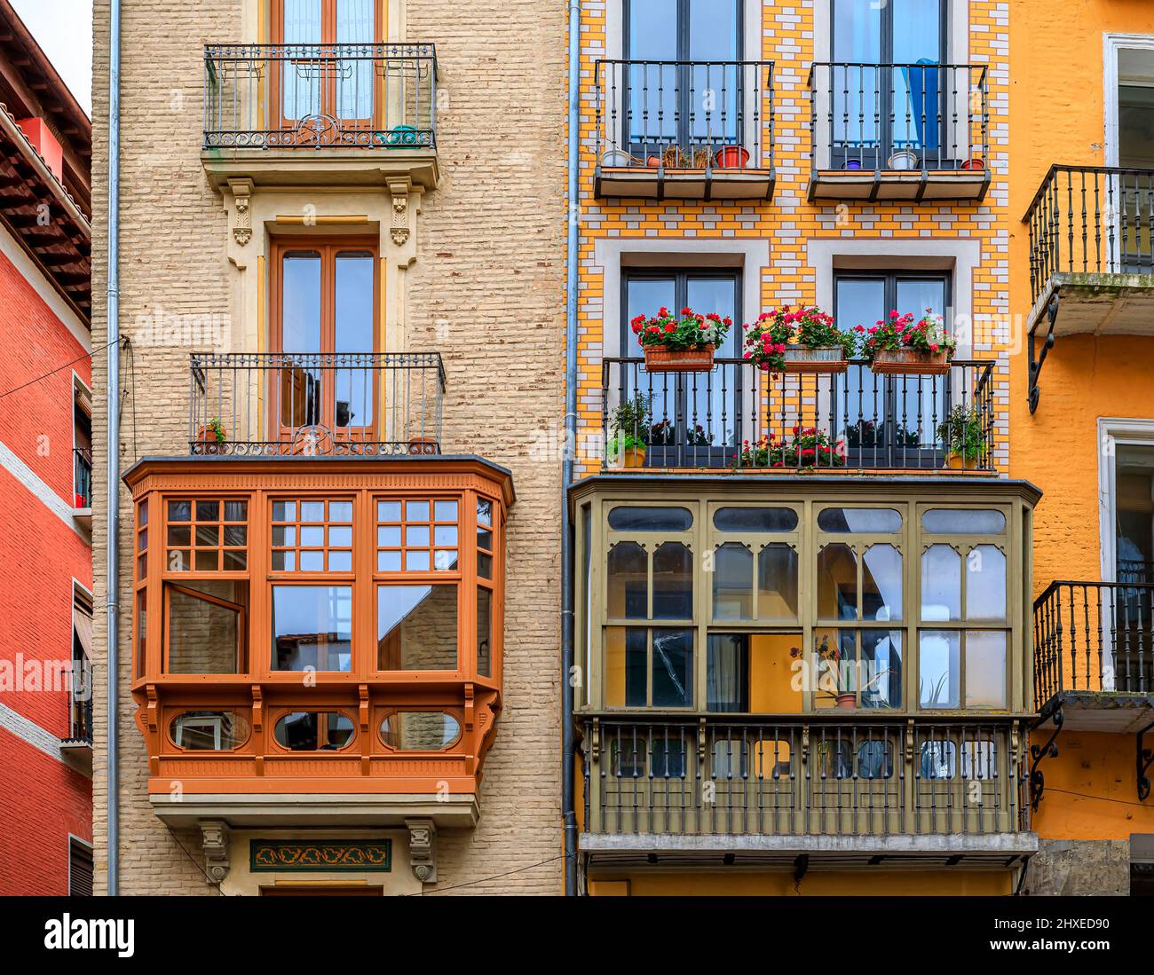 Colorful house facades and ornate metal balconies with flowers in the ...