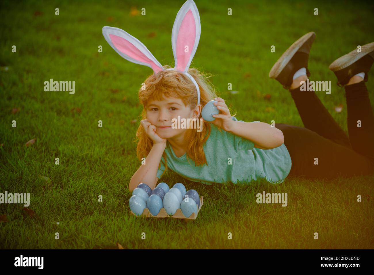Easter bunny children. Kids boy in bunny ears hunting easter eggs Stock